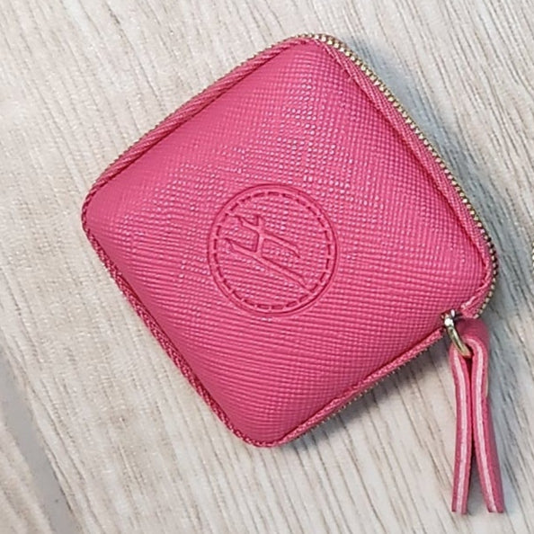 Two small rectangular pouches, one blue and one pink, on a wooden floor.