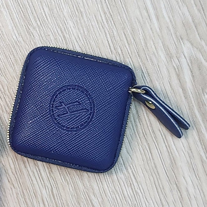 Two small rectangular pouches, one blue and one pink, on a wooden floor.