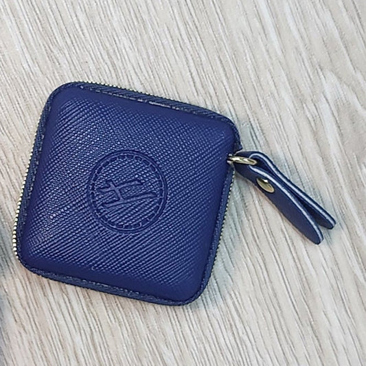 Two small rectangular pouches, one blue and one pink, on a wooden floor.