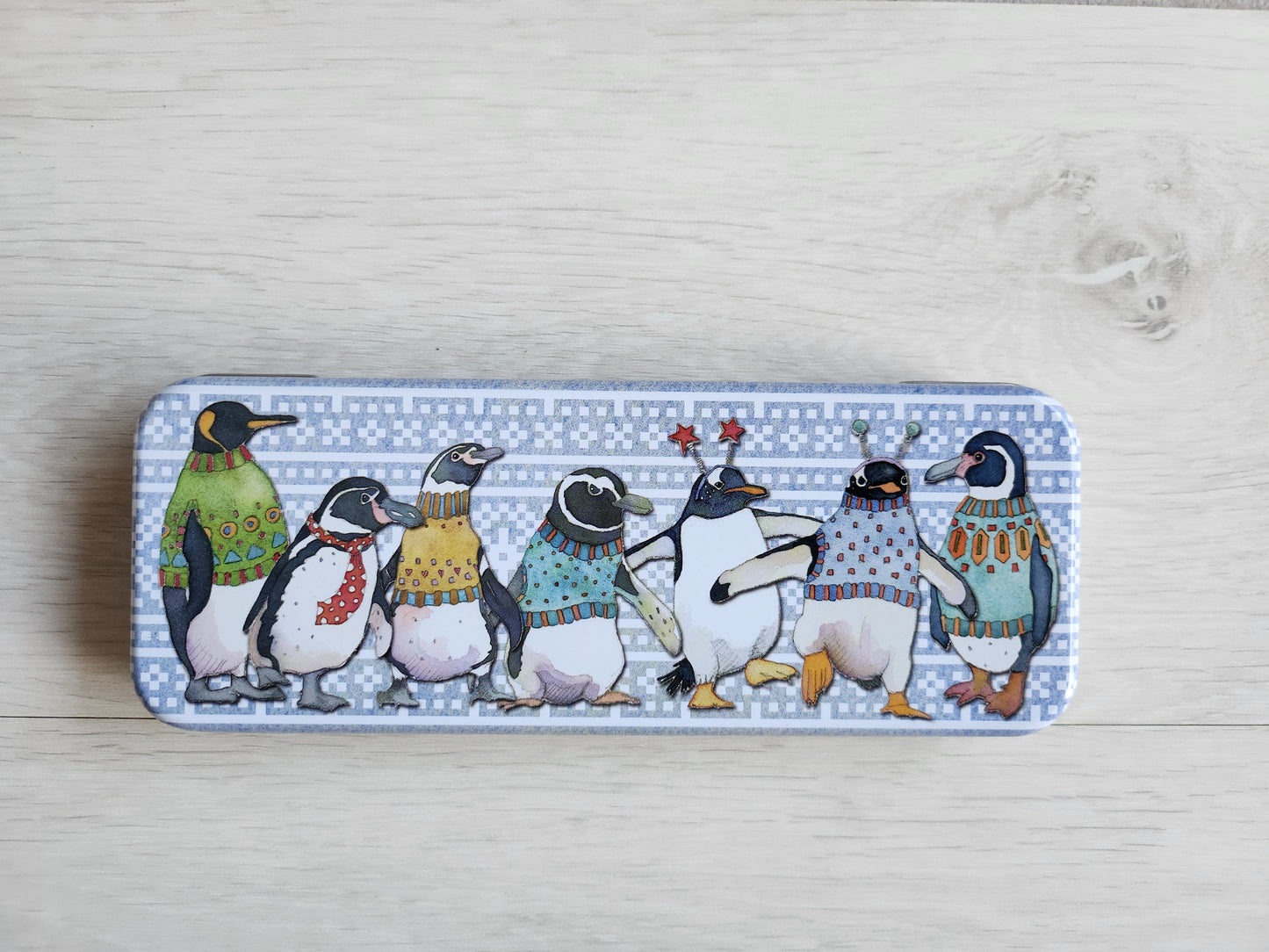 Pencil case with penguin design on a wooden surface
